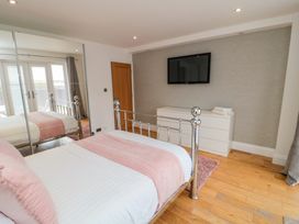 A bedroom with a bed and television at Wyvill House in Cayton