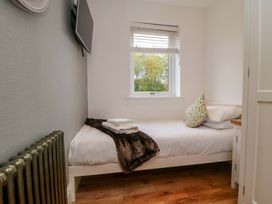 A bedroom with a bed and television at Wyvill House in Cayton