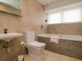A bathroom with a bathtub, toilet, and sink at Wyvill House in Cayton