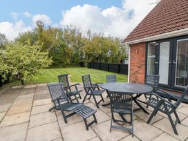 A patio with chairs and a table at Wyvill House in Cayton