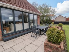 A garden with a table and chairs at Wyvill House in Cayton