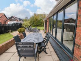 An outdoor patio with a table and chairs at Wyvill House in Cayton