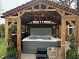 An outdoor area with a hot tub and wooden structure at High House in Southrepps