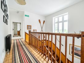 A hallway with stairs and a mirror at High House in Southrepps