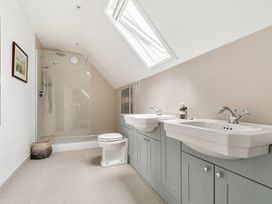 A bathroom with a shower and double sink at High House in Southrepps
