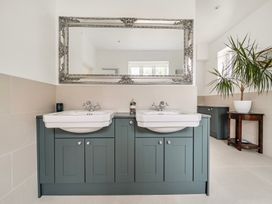 A bathroom with double sinks and a large mirror at High House Southrepps