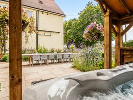 A garden with a hot tub and outdoor dining area at High House in Southrepps