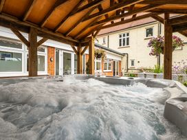 A hot tub under a wooden structure at High House in Southrepps