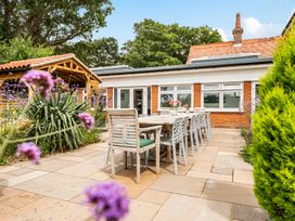 An outdoor seating area with a dining table and chairs at High House in Southrepps