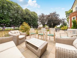 A patio with seating and plants at High House in Southrepps