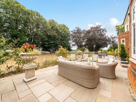An outdoor seating area with a table and planter at High House in Southrepps