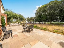 An outdoor patio with a table and chairs at High House in Southrepps