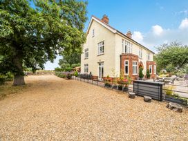 An exterior view of a house with a gravel pathway and garden at High House in Southrepps