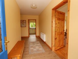 A hallway with a bench and a painting at 29 Church Field in Doonbeg, County Clare