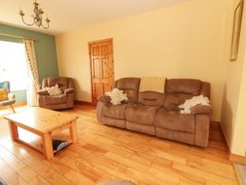 A living room with a sofa and armchairs at 29 Church Field, Doonbeg, County Clare