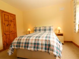 A bedroom with a bed and bedside lamps at 29 Church Field in Doonbeg, County Clare