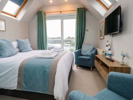 A bedroom with a bed and television at Alltwen in Borth-y-Gest