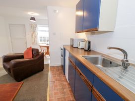 A kitchen with appliances and seating area at Min Y Mor in Llanystumdwy near Criccieth