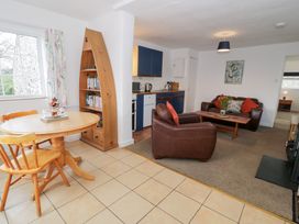 A living room with a sofa table and bookshelf at Min Y Mor in Llanystumdwy near Criccieth