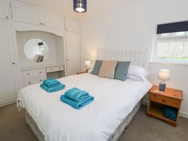 A bedroom with a bed and wardrobe at Min Y Mor in Llanystumdwy near Criccieth