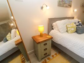A bedroom with a bed and nightstand at Driftwood in Marazion