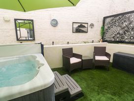 An outdoor area with a hot tub and seating at Driftwood in Marazion