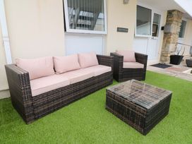 A seating area with a sofa, armchairs, and a coffee table at Driftwood in Marazion