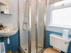 A bathroom with a shower, sink, and toilet at Seaward in Trimingham