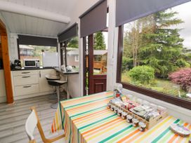 A kitchen with a table and chairs at Babbling Brook in Bron Aber near Blaenau Ffestiniog