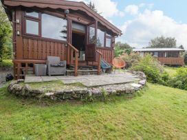 A cabin with a patio and outdoor furniture at Babbling Brook in Bron Aber near Blaenau Ffestiniog