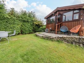 A garden with a cabin and outdoor seating at Babbling Brook in Bron Aber near Blaenau Ffestiniog