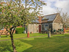 A house with trees and benches in the garden at Carthouse Brean