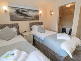 A bedroom with two beds and a bathroom at Carthouse in Brean