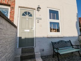 A front door with a window and a bench outside a brick house at Pipit House in Whitby