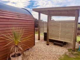 An outdoor area with gravel, a plant, a wooden structure, and a shower at Stargaze in Ponsanooth