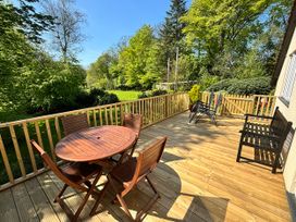 A deck with a wooden table and chairs at Little Oaklands Lostwithiel