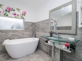 A bathroom with a bathtub and a glass wash basin at Hazelodge in Coniston