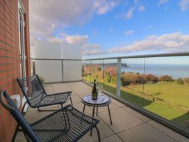 A balcony with chairs and a table overlooking the sea at The Lookout 
