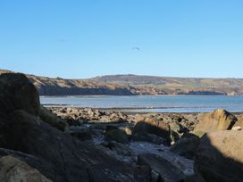 A view of rocks by the sea with hills in the background at The Lookout