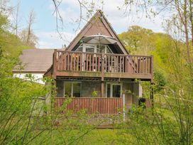 A house with a balcony and trees surrounding it at Hideaway Cottage, St Ann's Chapel, Cornwall