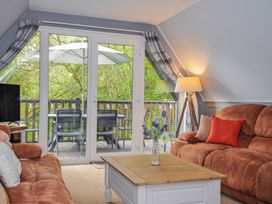 A living room with a television and sofa at Hideaway Cottage in St Ann's Chapel, Cornwall