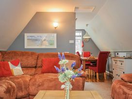 A living room with a sofa and dining area at Hideaway Cottage in St Ann's Chapel, Cornwall