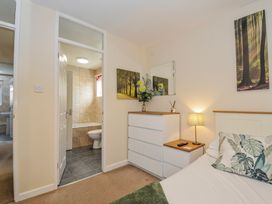 A bedroom with a dressing table and an en-suite bathroom at Hideaway Cottage St Ann's Chapel, Cornwall