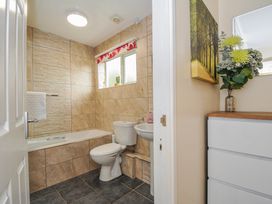 A bathroom with a tub, toilet, sink and cabinet at Hideaway Cottage St Ann's Chapel Cornwall