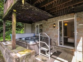 A hot tub with steps on a patio at Hideaway Cottage, St Ann's Chapel, Cornwall