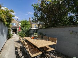 A garden with a dining table and chairs at Mallards Bourton-On-The-Water