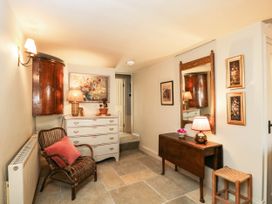 A hallway with a chest of drawers and a mirror at Mallards in Bourton-On-The-Water
