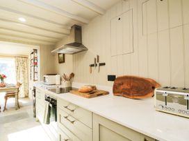 A kitchen with appliances and a dining area visible at Mallards, Bourton-On-The-Water