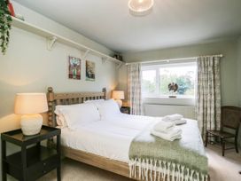 A bedroom with a bed and nightstand at Mallards Bourton-On-The-Water