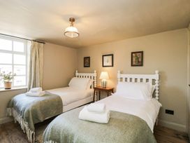 A bedroom with two beds and a lamp at Mallards in Bourton-On-The-Water